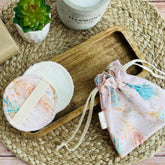 Reusable face wipes, white and pink patterned, with drawstring bag