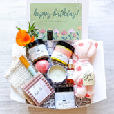 Bath & body gift set with pink, white, and orange items, Nizzy Naturals products in a box with flowers