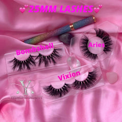 False eyelashes with black synthetic fibers in clear plastic cases on pink satin fabric