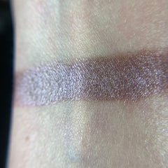 Side view of Strange Eye Shadow Palette displaying twelve vibrant matte and shimmer shades in sleek black compact