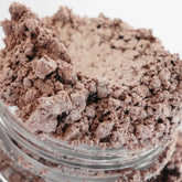 Eyeshadow makeup in taupe-pink color with shimmer, in a clear jar with product visible