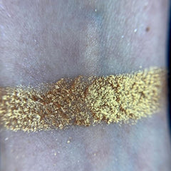 Close-up of shimmery bronze and copper eye shadows with smooth, blendable texture in a sleek black palette