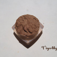 Side view of three round mineral eyeshadow pans in fall brown shades: matte basic, shimmer showstopper, and sparkly tigerlily