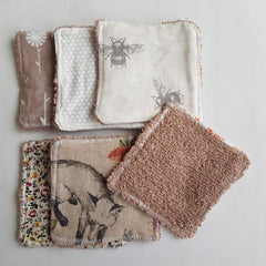 Reusable face pads with various patterns and colors, including floral, bee, and textured brown fabric