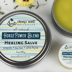 Bee propolis salve, metal tin with striped pattern, Deep Well Botanicals branding visible