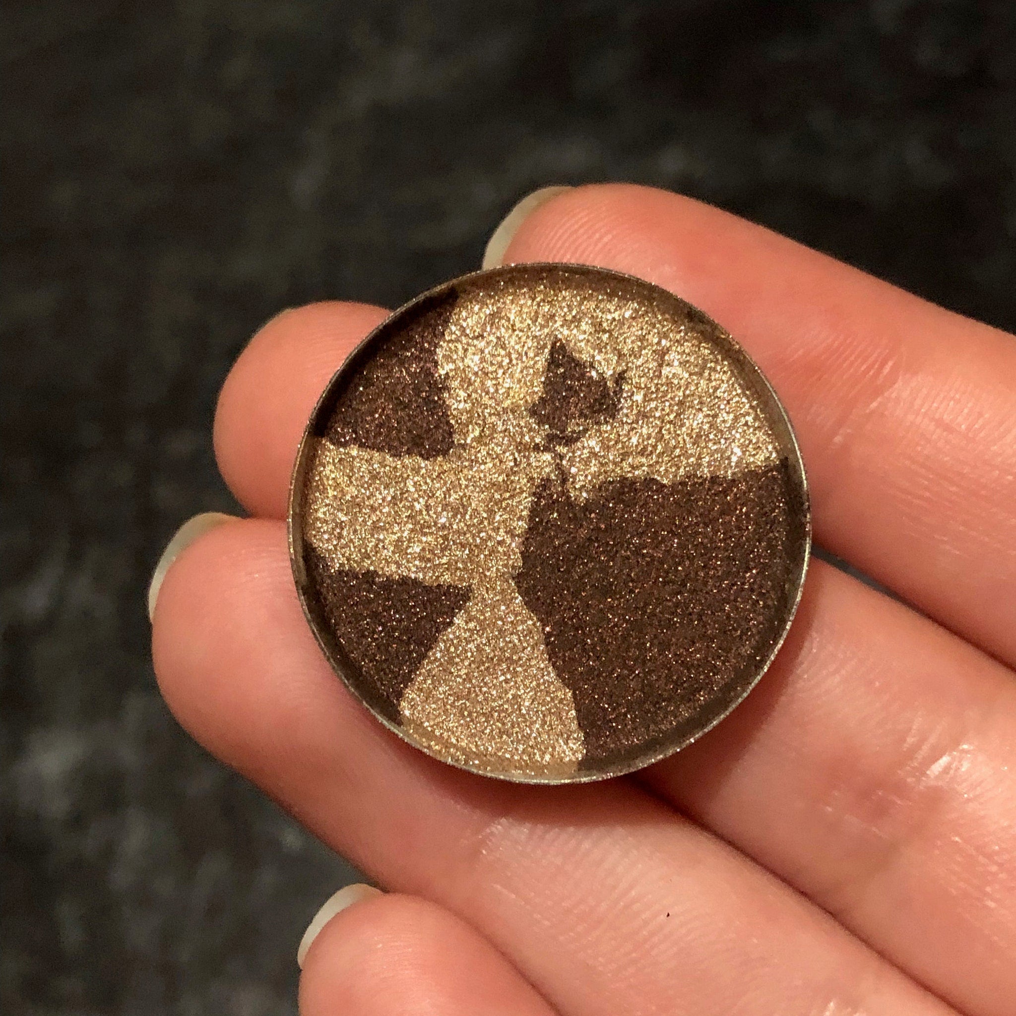 Single pressed eyeshadow in a sleek black compact with a mirrored lid, showcasing a metallic mercury silver shade.