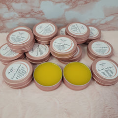Lip balm tins with pink lids and yellow balm, "Ouu Latte's Beauty" brand visible