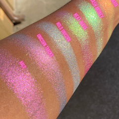 Swatch of multichrome unicorn tracks eyeshadow showing color shift from purple to teal on fingertip