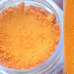 Matte eyeshadow, orange powder in jar and swatch, close-up view