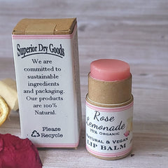 Lip balm with pink color, cardboard tube, and Rose Lemonade label next to a box