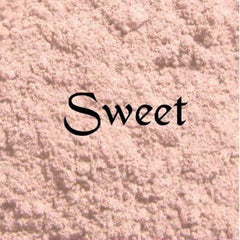 Close-up of matte pink vegan eyeshadow with silky texture and mineral quartz flecks in compact case