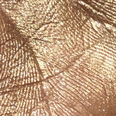 Close-up of a hand applying shimmery silver eye shadow with a blending brush for a soft, diffused look