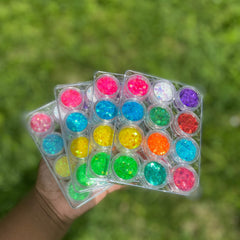 Close-up of iridescent glitter eyeshadow palette showing 12 vibrant shades with shimmer finish