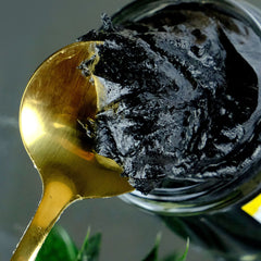 Black glass jar of charcoal cleansing balm with matte lid and minimalist white label