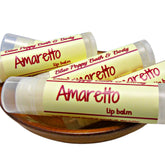 Lip balm tubes with yellow labels, Amaretto text, and Blue Poppy Bath & Body brand, in a wooden bowl