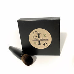 Hand applying golden mineral eye shadow with a brush onto eyelid, showcasing smooth pigment blend