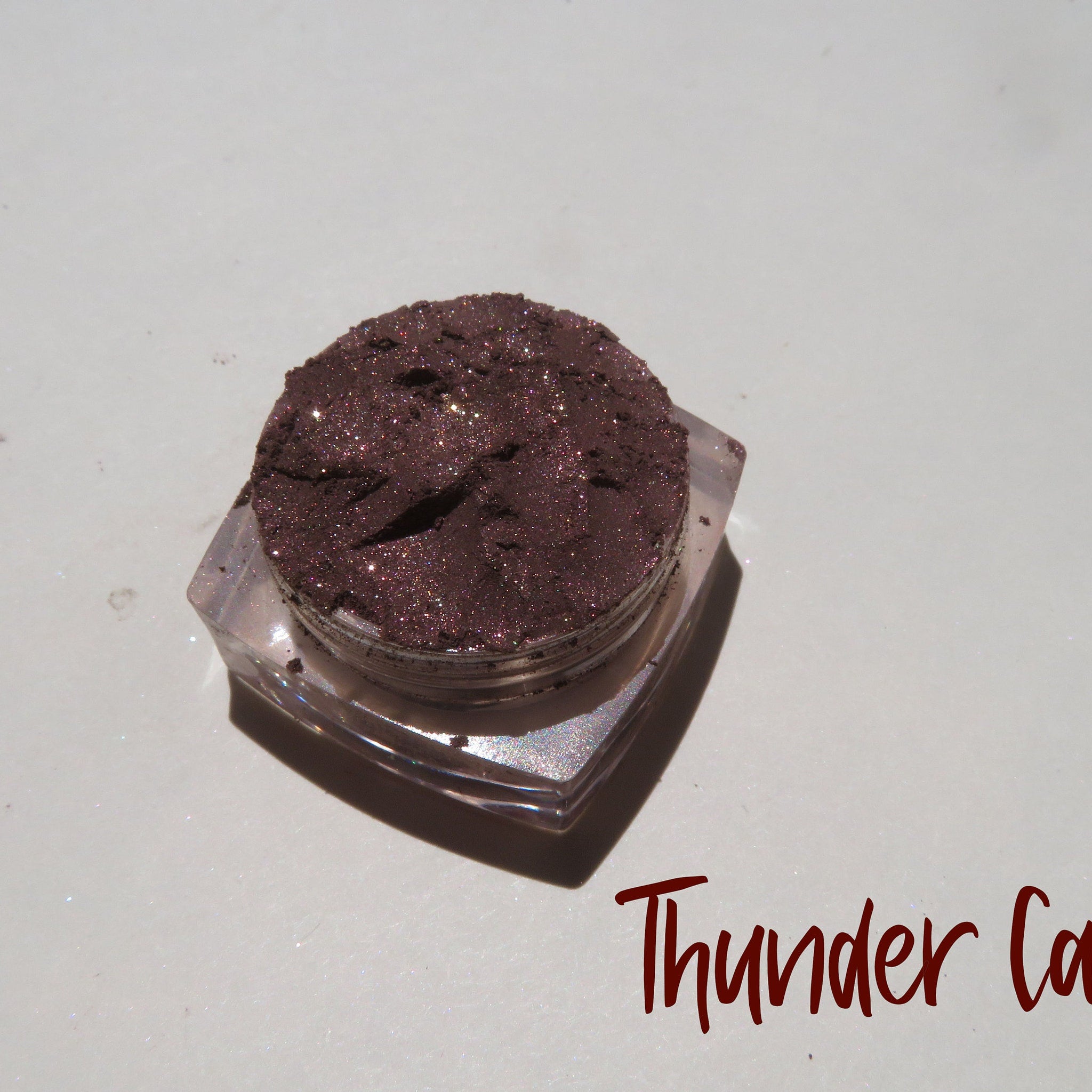 Glass jar of dark brown shimmer loose mineral eye shadow with metallic finish, vegan and eco-friendly