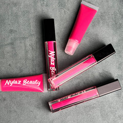 Lip gloss tubes in bright pink with black caps, "Nylaz Beauty" text visible on product packaging