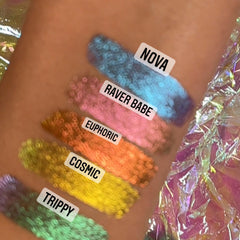 Swatches of blue, pink, orange, yellow, and green glitter on skin with "NOVA" "RAVER BABE" "EUPHORIC" "COSMIC" "TRIPPY" text