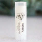 Lip balm tube with white color, floral illustration, and "Almond" text