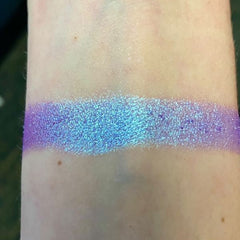 Close-up of Moonlight Masquerade Eye Shadow palette showing shimmering silver and deep navy shades with smooth powder texture