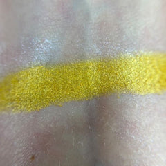 Yellow eyeshadow swatch with metallic shimmer on skin, used for makeup application