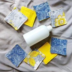 Reusable facial rounds with yellow trim, floral and paisley patterns, and white bottle
