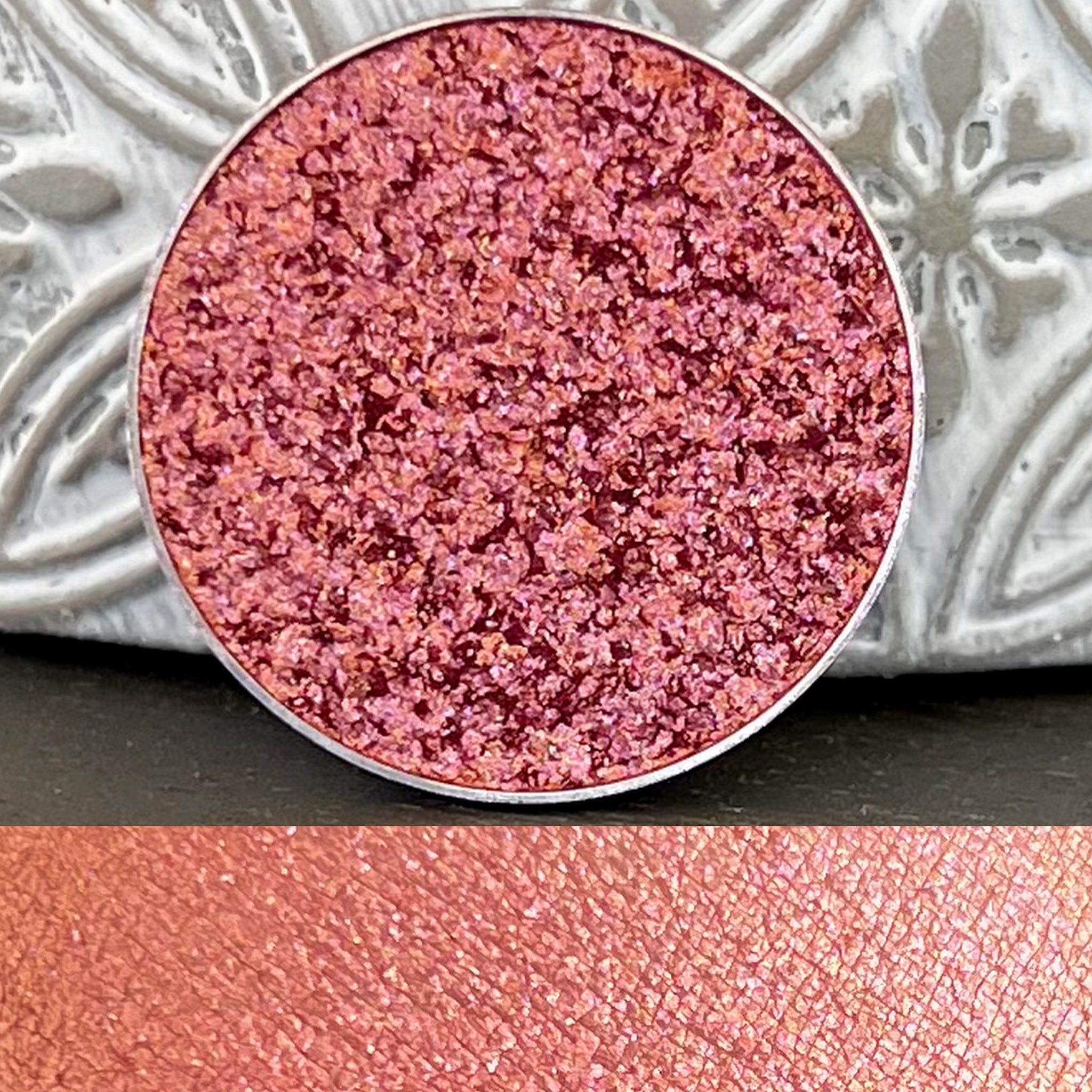Eyeshadow pan with multi-chrome pink color, metallic finish, and silver rim detail