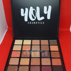 Hand applying shimmery taupe eyeshadow from palette with fingertip onto eyelid