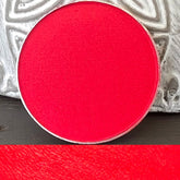 Matte pressed eyeshadow in a round 26mm pan with smooth, velvety texture and minimalist compact packaging