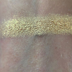 Close-up of shimmering bronze and plum eye shadows with smooth, blendable texture in compact palette