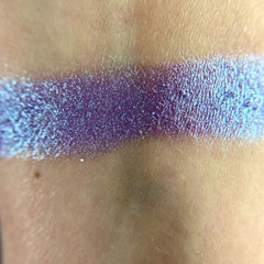Side view of Moonlight Masquerade Eye Shadow palette showing shimmering silver and deep navy shades in rectangular pans