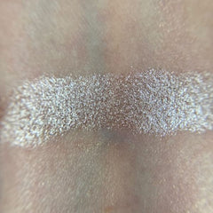 Close-up of shimmery champagne eye shadow with sparkling flecks in compact palette