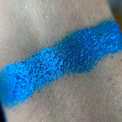 Close-up of shimmering bronze and taupe eye shadow pans with smooth, blendable texture in sleek black palette