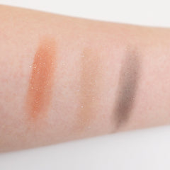 Sunset Peach eyeshadow pan with sheer orange sequin shimmer on a clean white surface