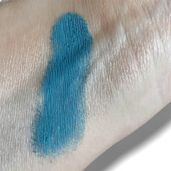 Blue swatch on skin, showing color and texture of the product applied for testing purposes