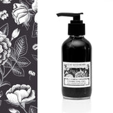 Facial cleanser bottle with black liquid, pump, and white label, Leaf Seed Berry brand