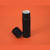 Lip balm tubes, black cardboard push-up style with white interior and orange background