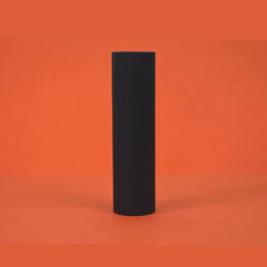 Black cylindrical container on orange background, matte finish, minimalist design