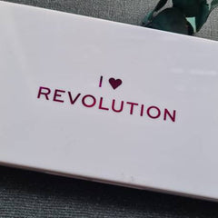 Woman applying vibrant teal eyeshadow from palette with a fluffy blending brush for a bold 80s makeup look