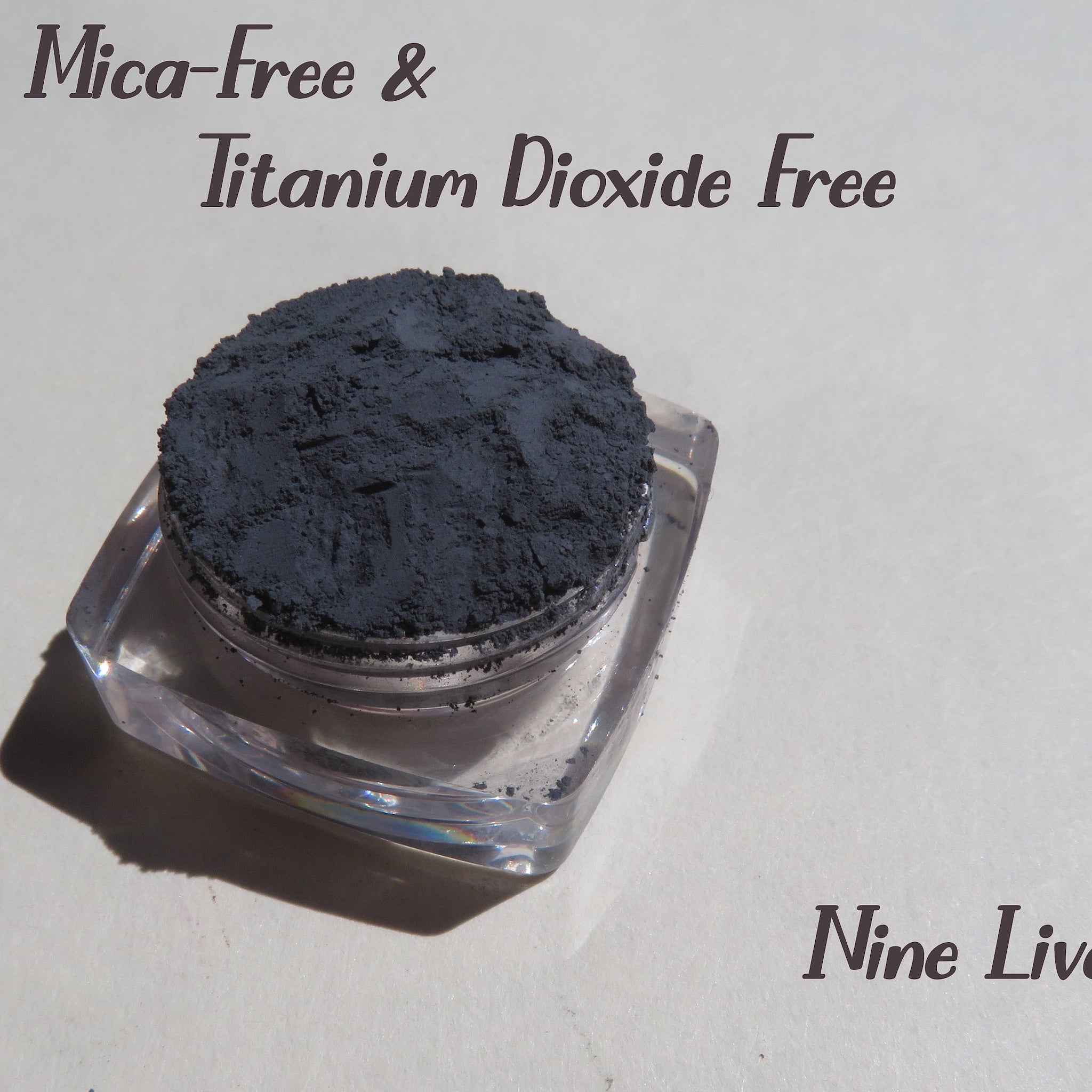 Eyeshadow powder dark gray matte pigment in clear jar, Nine Lives brand
