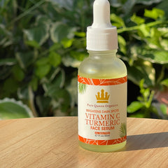 Close-up of golden vitamin C turmeric serum with dropper, showcasing its smooth, glowing texture on fingertips