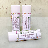 Lip balm tubes with white caps and floral pattern, Green Daffodil brand visible