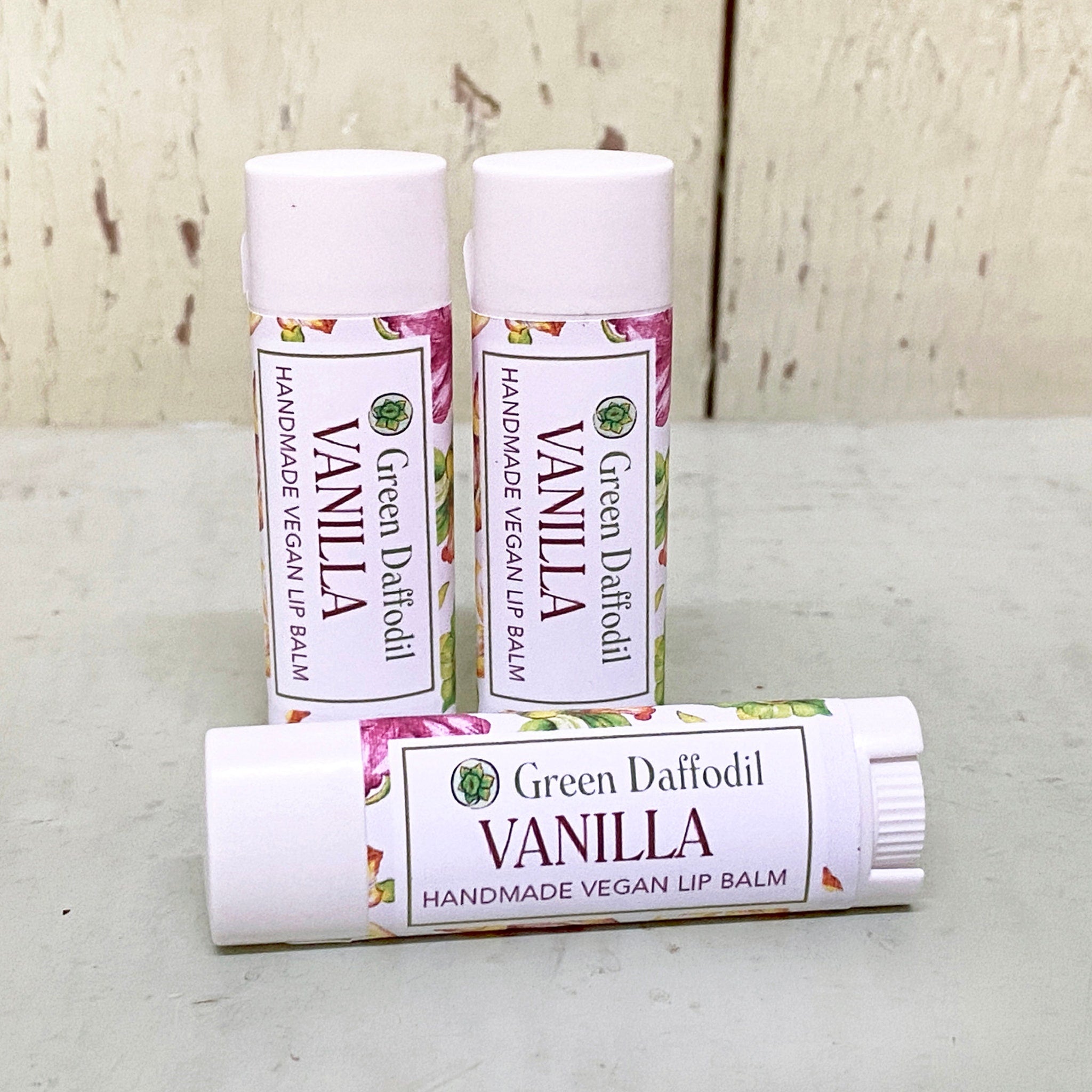 Vanilla lip balm tubes, white with floral pattern and Green Daffodil text, for moisturizing lips