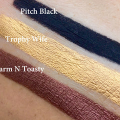 nan swatches black, gold, and brown with TROPHY WIFE text visible on skin