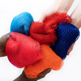 African net sponges in red, blue, and orange mesh, held by hands