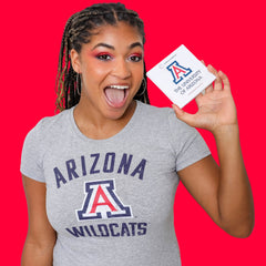 Close-up of fingertips applying shimmering copper eye shadow to eyelid with soft blending brush