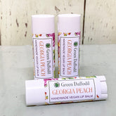 Lip balm tubes with white caps, floral pattern, and Green Daffodil Georgia Peach label