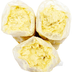 Close-up of golden unrefined shea butter in a glass jar with creamy texture and natural lumps visible