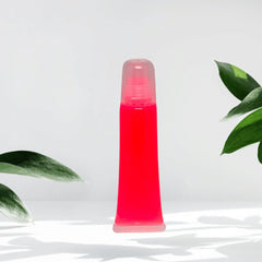 Lip gloss tube with red liquid, clear plastic, and transparent cap, on white surface